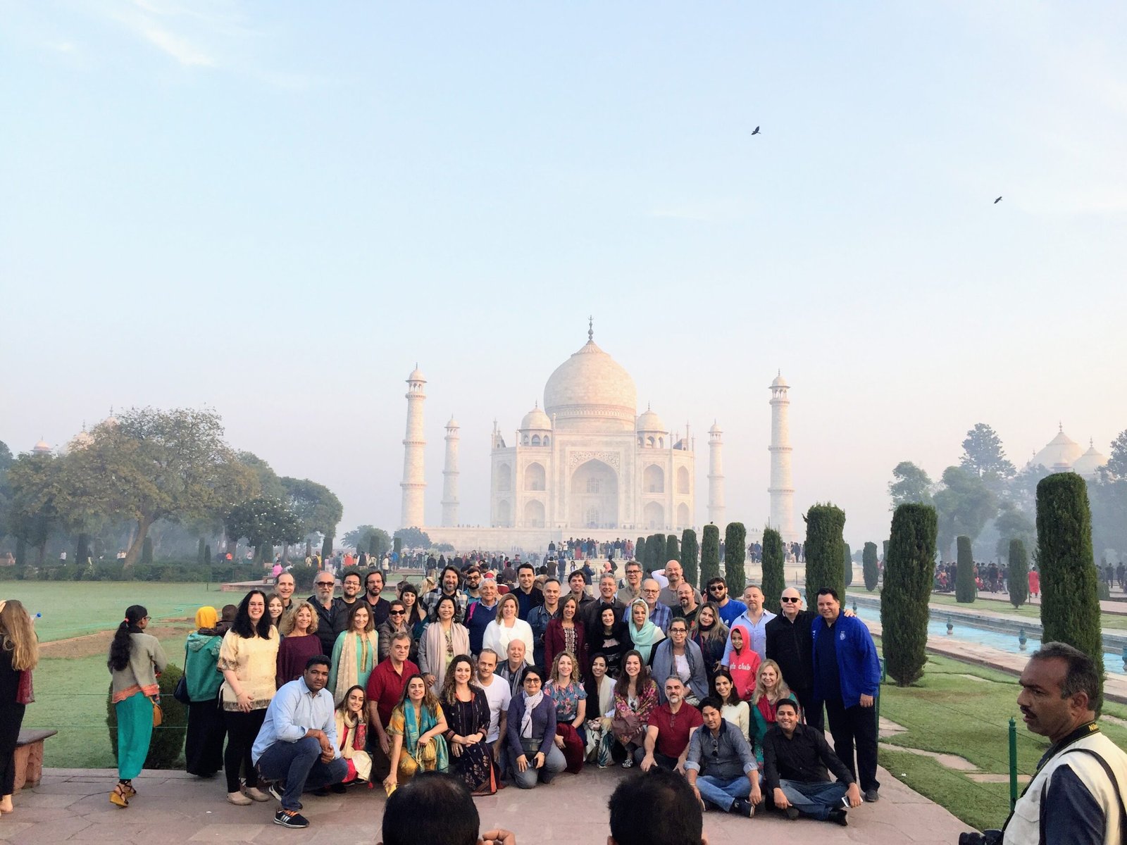 A group of tourists in a photo at the Taj Mahal, exploring 2025 ticket prices—a complete guide for French travelers.