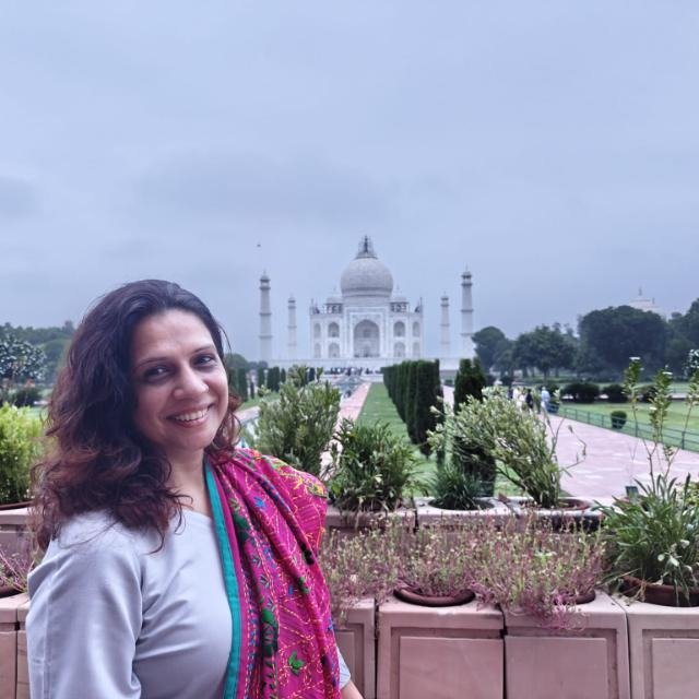 Solo traveler exploring the Taj Mahal at sunrise with soft golden light on the white marble, peaceful atmosphere, and light crowd near entrance, Agra India – Taj Mahal Cabs travel guide