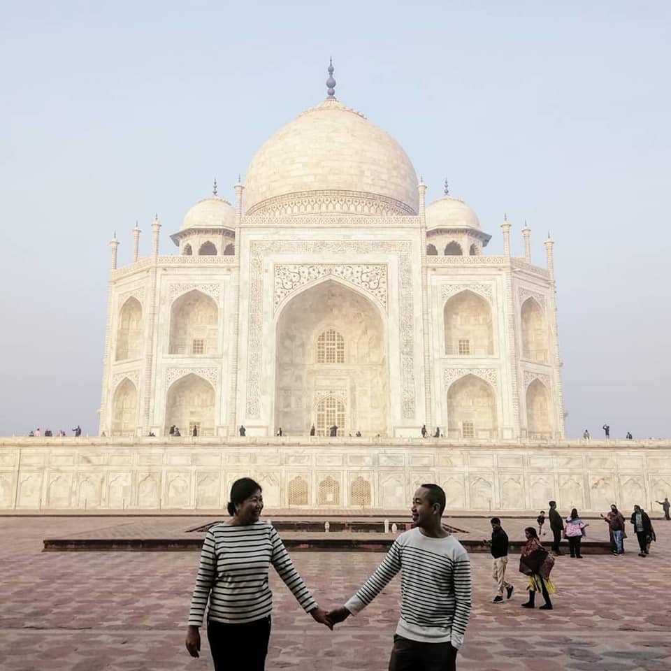 Couple visiting the Taj Mahal in Agra on a Sunday, enjoying the gardens and white marble monument