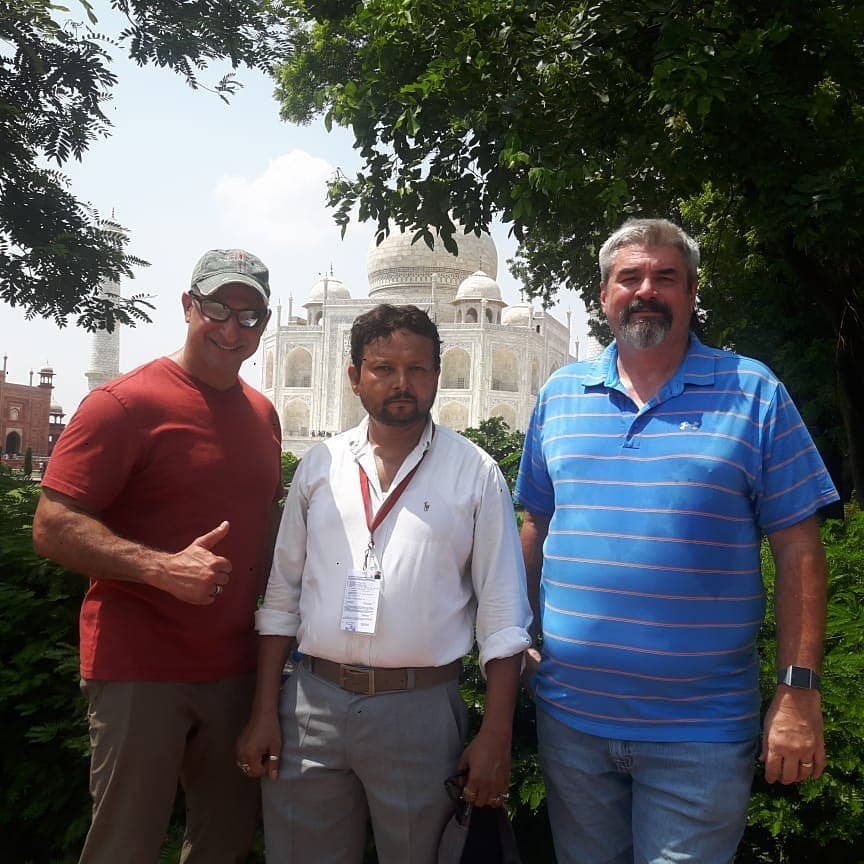 Two tourists with a licensed guide at the Taj Mahal during a sunrise tour from Delhi